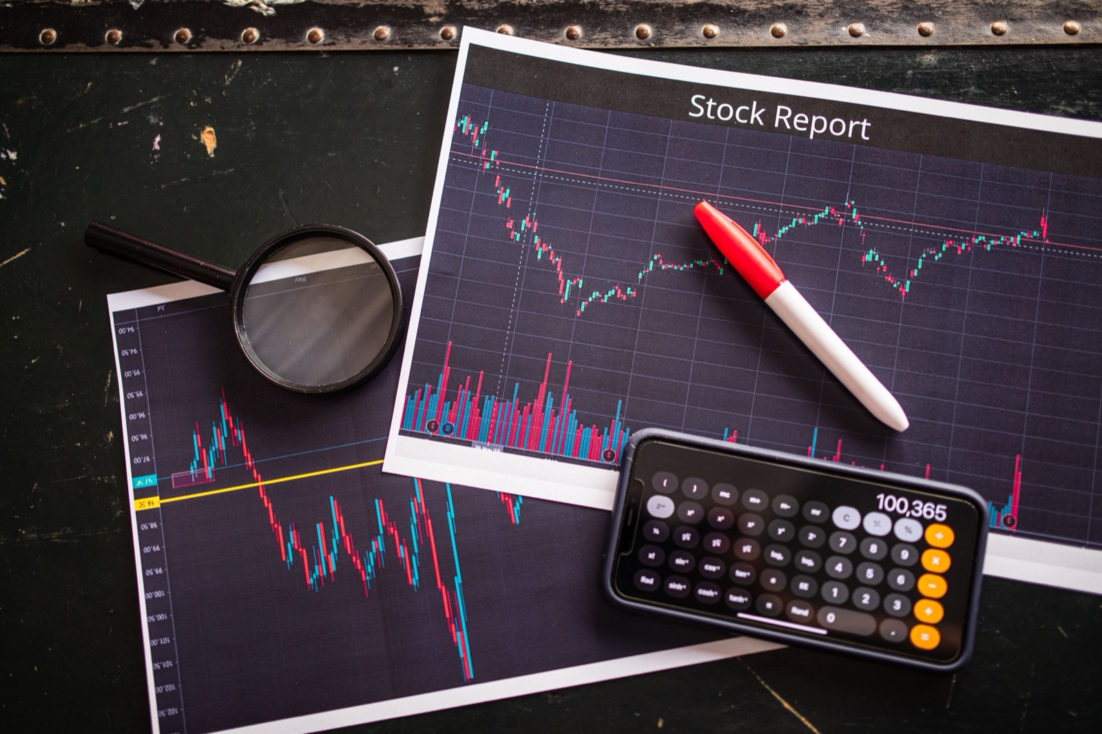 A candlestick stock price chart on a dark trading screen, falling then rising to a peak before pulling back